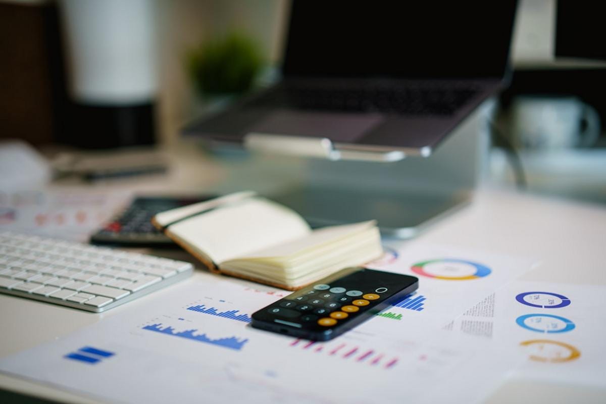 Modern office environment with financial analysts discussing market data on digital screens.